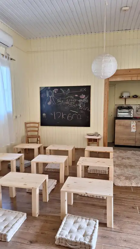 כיתה עם שולחנות עץ ולוח גיר